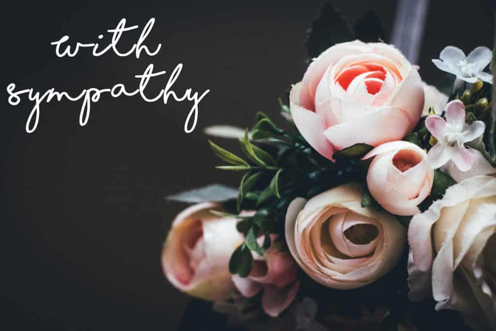 Flowers with sign that says "with sympathy" one of thoughtful miscarriage gifts that can be given