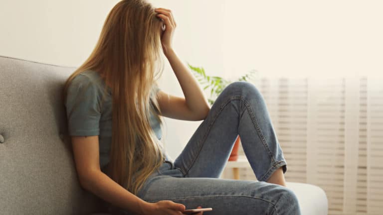 depressed young woman with phone