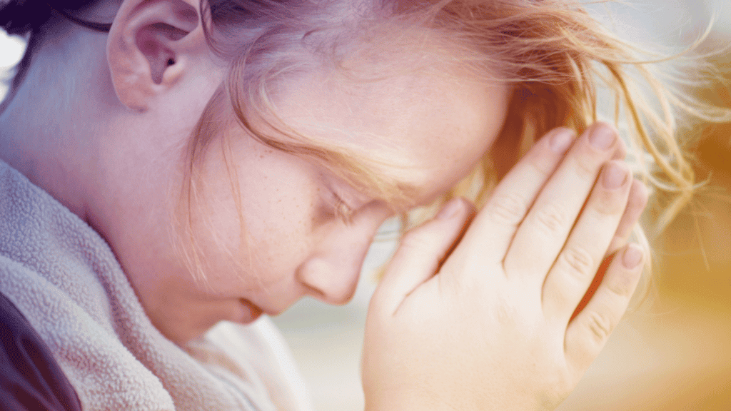 family prayer. young, blonde child with her head bowed to pray, and her hands folded in prayer.