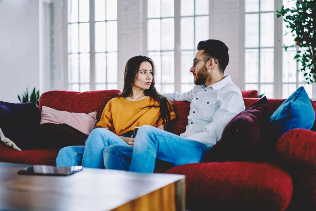 A couple sitting on the couch communicating with clarity, timing and tempo.