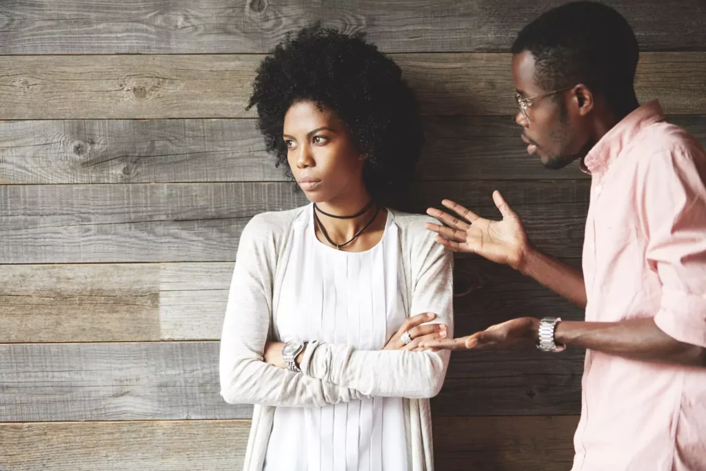 Fighting can help your marriage if you learn to have healthy conflict. A man and woman in a fight, The man pleads his case as the woman looks away, arms folded across her chest.