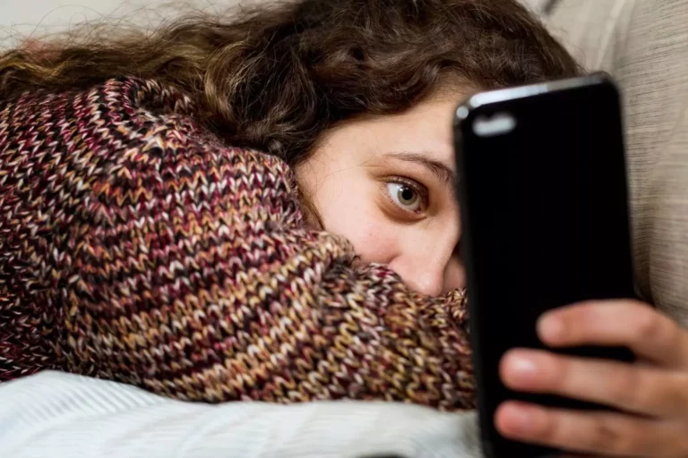 Manifesting your dreams through social media. Young girl laying on a couch looking at her phone