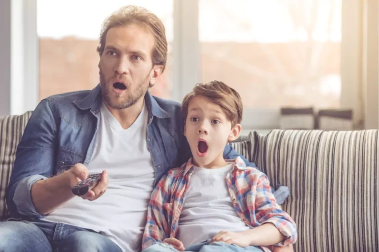 shocked father and son watching tv. Trying to navigate inappropriate content