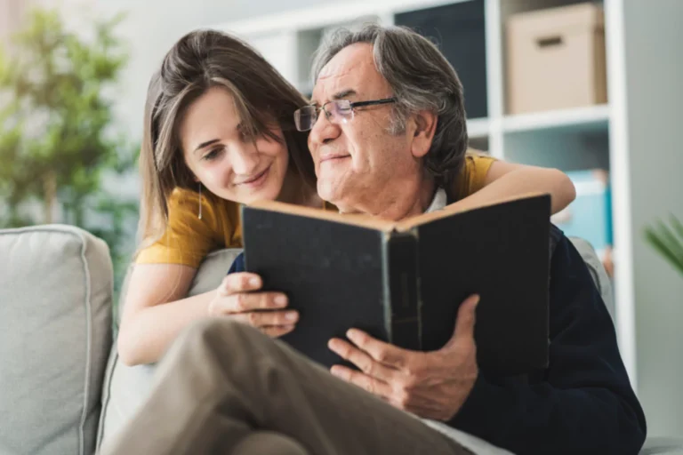 teens spiritual gifts. Teenage girl hugging her father from behind who is reading the bible